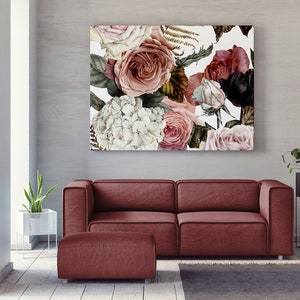Könnte beinhalten: Ein rotes Sofa mit einem passenden Hocker vor einer Wand mit einem floralen Leinwanddruck. Die Leinwand zeigt rosa, weiße und rote Rosen mit grünen Blättern.