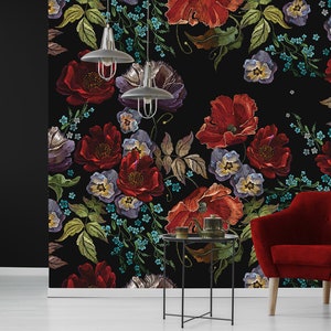 May include: A black background with a floral pattern featuring red, purple, and blue flowers. The flowers are embroidered and have a vintage style. The background is black and the flowers are colourful.
