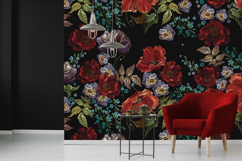 May include: A black background with a floral pattern featuring red, purple, and blue flowers. The flowers are embroidered and have a vintage style. The background is black and the flowers are colourful.