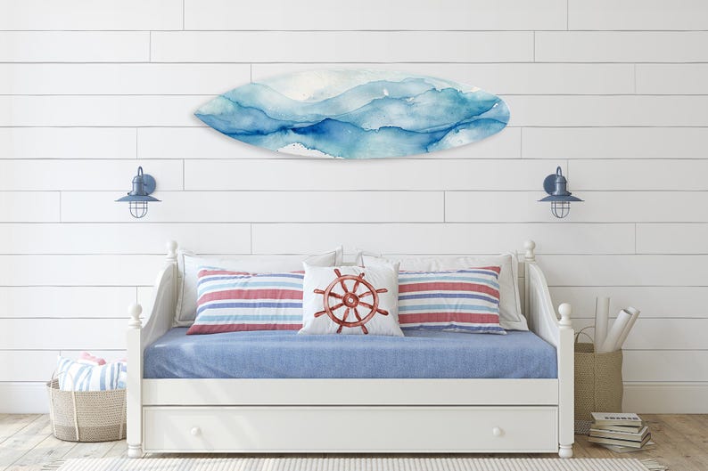 May include: A coastal-themed bedroom with a white daybed, blue bedding, and striped pillows. A surfboard-shaped wall art with blue watercolor design hangs above the bed. Nautical decor includes a pillow with a ship's wheel design.
