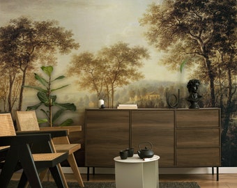 Op de afbeelding: Een houten kast met twee deuren en drie laden, een ronde witte bijzettafel met een zwarte theepot en drie kopjes, en twee zwarte stoelen met gevlochten zittingen voor een muurschildering die een landschap met bomen en een huis voorstelt.