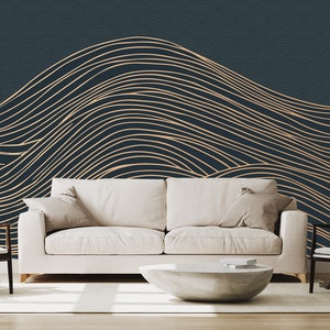 May include: A living room interior design with a white sofa and two chairs, a white coffee table, and a floor lamp. The wall behind the furniture is decorated with a dark blue wallpaper with a pattern of gold wavy lines.