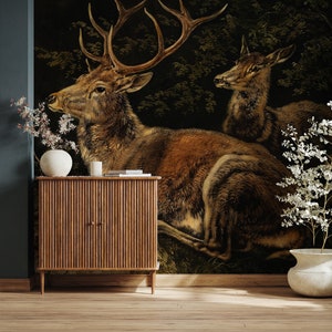 Puede incluir: Una ilustración de estilo vintage de dos ciervos en un entorno de bosque oscuro. Los ciervos son marrones y tienen grandes cuernos. El fondo es de color verde oscuro y marrón.