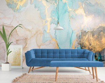 May include: A blue sectional sofa with a matching ottoman in front of a wall with a blue and gold abstract marble pattern.