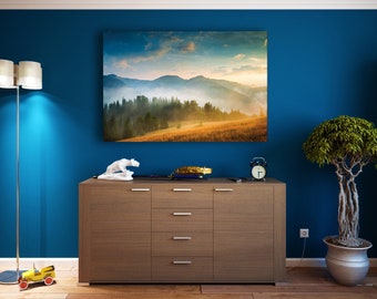 Könnte beinhalten: Eine Kommode aus Holz mit fünf Schubladen, eine weiße Keramiktierfigur, ein schwarzer Wecker und ein gerahmtes Landschaftsfoto eines Gebirges mit Nebel und Bäumen. Die Kommode steht an einer blauen Wand mit einem Topfbaum rechts.