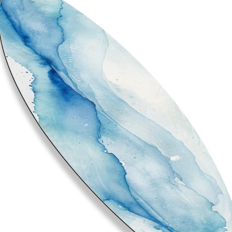 May include: An oval-shaped decorative item with a watercolor design. The artwork features flowing shades of blue and white, creating a soft, abstract pattern. The edges are outlined with a thin black border, adding definition to the design.
