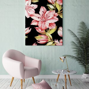 Puede incluir: Un sillón rosa con patas de madera se encuentra frente a una obra de arte de lienzo con estampado floral en blanco y negro. Una pequeña mesa de mármol con patas de madera se encuentra junto al sillón. Una lámpara dorada y un jarrón de vidrio transparente con agua están sobre la mesa.