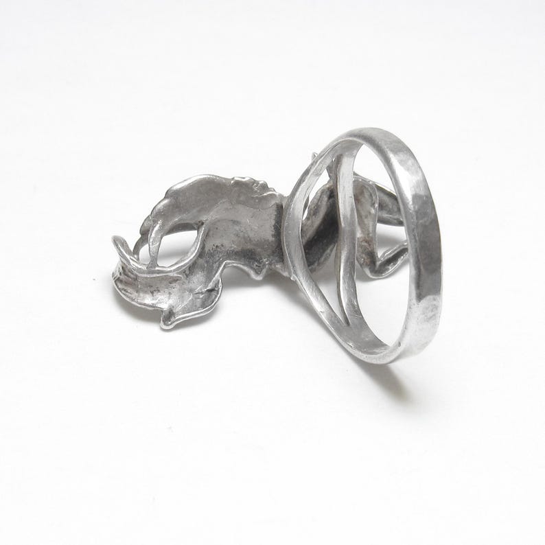 Puede incluir: Anillo plateado con un dise&ntilde;o detallado de rinoceronte. El anillo tiene un acabado texturizado y una banda ancha. La cabeza y el cuerno del rinoceronte se muestran de forma prominente.