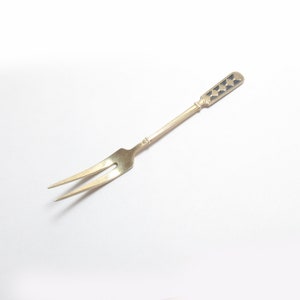 May include: A silver cake fork with a decorative handle featuring a blue and gold design.