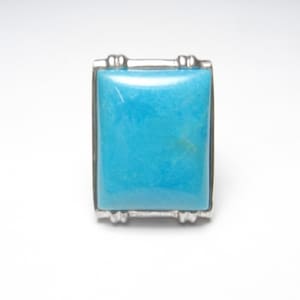May include: A square turquoise stone ring with a silver setting.