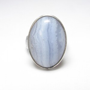 May include: A silver ring with a light blue agate stone set in a bezel setting.