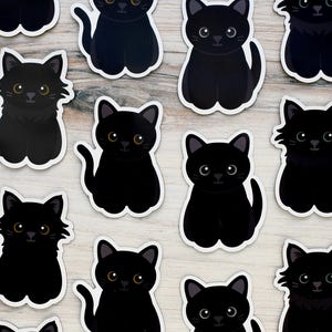 May include: A sheet of black cat stickers. Each sticker features a black cat with yellow eyes. The cats are in various poses, including sitting, standing, and lying down.