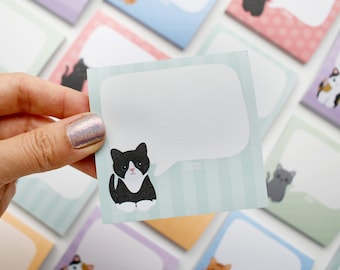 Könnte beinhalten: Ein hellblaues Haftnotiz mit Sprechblasen-Design und einer schwarz-weißen Katzenillustration. Weitere bunte Haftnotizen mit Katzenillustrationen befinden sich im Hintergrund.