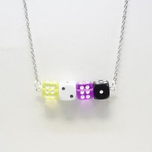 May include: A silver chain necklace with four dice charms. The dice are yellow, white, purple, and black.