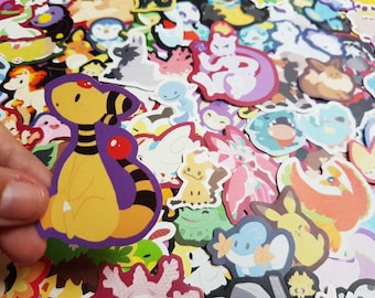 Puede incluir: Una colección de pegatinas coloridas con varios personajes de dibujos animados. Las pegatinas son de varias formas y tamaños, con un enfoque en un personaje amarillo y morado. Las pegatinas están sobre una superficie blanca.