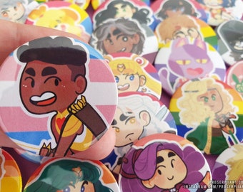 May include: A collection of colorful button pins featuring cartoon characters. The pins are round and have a white background with a colorful design. The characters are all smiling and have different hairstyles and clothing. The pins are arranged in a random order.