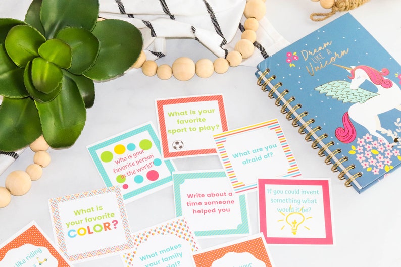 May include: Colorful cards with questions to spark conversation.  The cards have a variety of colors and patterns.  The text on the cards includes questions like "What is your favorite color?" and "Who is your favorite person in the world?"