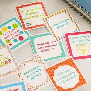May include: A set of colorful cards with prompts for conversation starters. The cards feature a variety of designs and colors, including red, orange, yellow, green, blue, and white. The text on the cards includes questions such as "What is your favorite color?" and "Who is your favorite person in the world?"
