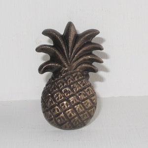 May include: A bronze pineapple-shaped door knocker with a detailed design.