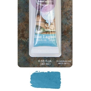 Könnte beinhalten: Eine Tube blauer Metallic-Wachs mit der Aufschrift "El alchemy METALLIQUE WAX CIRE CERA Blue Lagoon" mit einer Größe von 0,68 fl. oz. (20 ml).