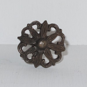 Peut inclure: Un bouton de porte en métal de couleur bronze avec un motif floral.