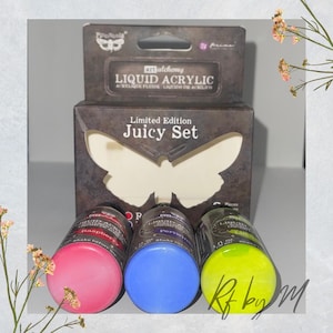 May include: A set of three 1 oz bottles of liquid acrylic paint in a limited edition "Juicy Set". The bottles are labeled "Raspberry", "Periwinkle", and "Lime". The paint is by the brand "Pina" and is part of their "Alchemy" line.