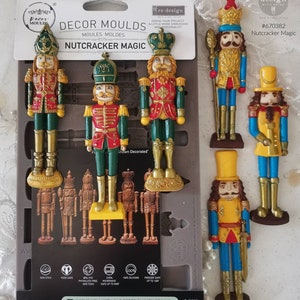 May include: A set of six silicone molds for making nutcracker figurines. The molds are shown with finished nutcrackers in various colors, including red, green, blue, and yellow. The molds are 5 inches by 8 inches and are made of 100% silicone. They are freezer safe up to 100 degrees Fahrenheit.