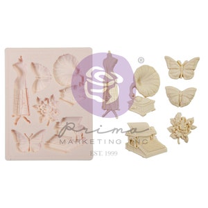 May include: A silicone mould with various designs, including a vintage gramophone, a typewriter, a butterfly, a flower, and a dress form. The mould is beige and has the text "Prima Marketing Inc. Est. 1999" on the bottom.