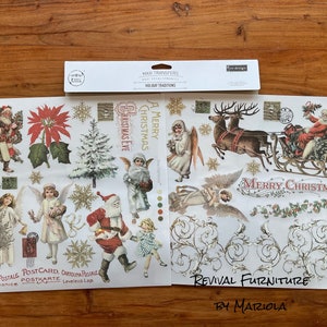 Op de afbeelding: Twee vellen wit papier met kerstthema-afbeeldingen erop gedrukt. De afbeeldingen omvatten de kerstman, engelen, rendieren, een kerstboom en de woorden "A Merry Christmas" en "Merry Christmas". De vellen zijn gelabeld "Maxi Transfers Holiday Traditions Revival Furniture by Mariola".