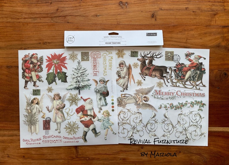 Op de afbeelding: Twee vellen wit papier met kerstthema-afbeeldingen erop gedrukt. De afbeeldingen omvatten de kerstman, engelen, rendieren, een kerstboom en de woorden "A Merry Christmas" en "Merry Christmas". De vellen zijn gelabeld "Maxi Transfers Holiday Traditions Revival Furniture by Mariola".