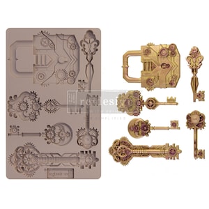 May include: A silicone mould with eight detailed designs of keys and a padlock, all with intricate gear and cog details. The mould is designed for creating decorative sugar paste or fondant embellishments for cakes and other desserts.
