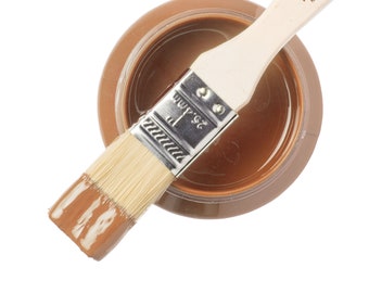 Può includere: Un piccolo barattolo di pittura minerale Fusion Chestnut Mare con un pennello immerso nella vernice. La vernice è di un colore marrone intenso.