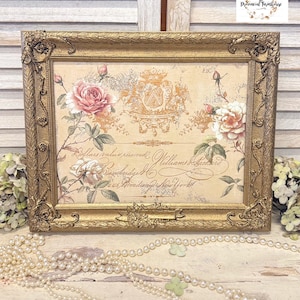 May include: A gold-framed picture with a vintage floral design featuring pink and white roses. The image includes a crest with a shield and two birds. The text "Dollars value received Williams & Brothers" is visible in the image.