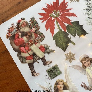Op de afbeelding: Een vel vintage kerst stickers met Sinterklaas die een zak met cadeaus draagt, een kerstster, een sneeuwvlok, een engel met een bel en een vintage postzegel.