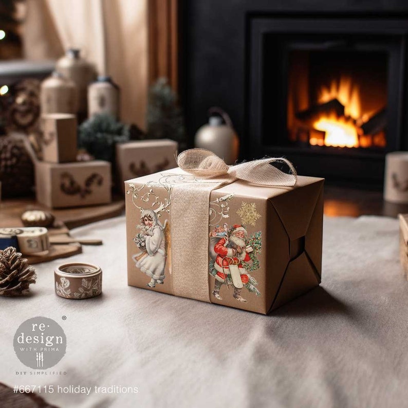 Op de afbeelding: Een bruine cadeaudoos verpakt in papier met een vintage kerstontwerp met Sinterklaas en een engel. De doos is vastgebonden met een beige lint en staat op een beige oppervlak voor een open haard.