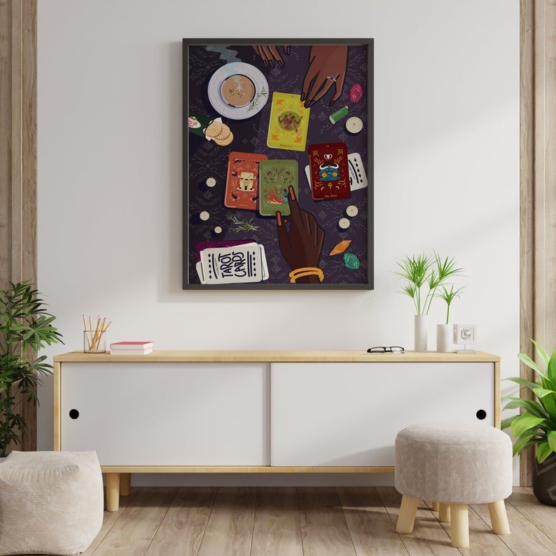 May include: A framed illustration of a tarot card reading with a cup of tea and several tarot cards spread out on a purple table cloth. The text "Tarot Cards" is visible on one of the cards.