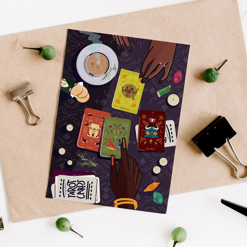 May include: A hand reaches for a tarot card spread on a dark purple surface. The cards are colorful and feature illustrations of various figures and symbols. The spread includes the cards "Empress", "The Devil", and "The Tower". The cards are surrounded by candles, crystals, and other mystical objects.