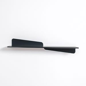 May include: A modern, black metal wall shelf with an asymmetrical design. The shelf features a long, horizontal surface with a raised back and a triangular extension on the right side. The shelf is mounted on a white wall.