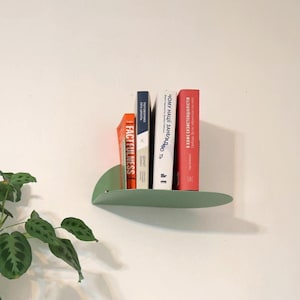Kleines salbeigrünes Metallregal, minimalistisches gebogenes schwebendes Bücherregal, modernes abgerundetes Nachttischregal, buntes Wandregal