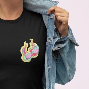 May include: Black t-shirt with a colorful graphic of a bra on fire.