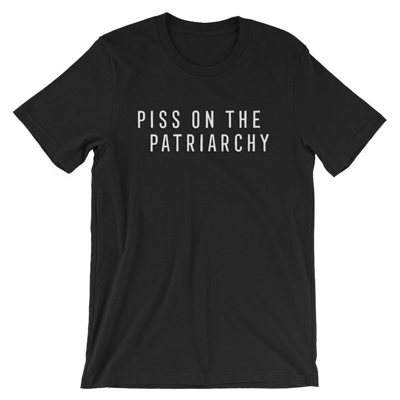 Puede incluir: Camiseta negra con el texto "PISS ON THE PATRIARCHY" impreso en blanco.