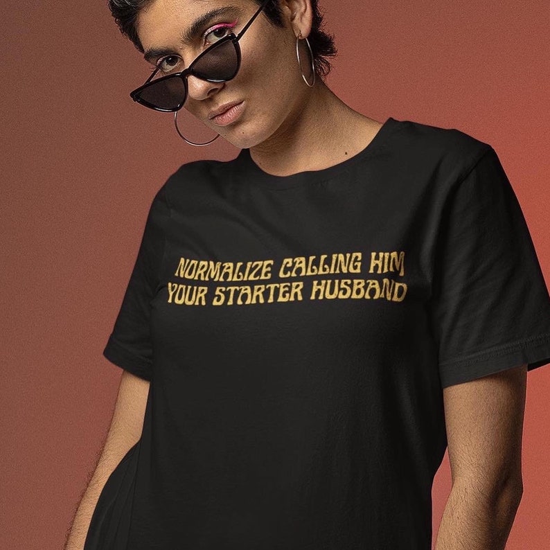 Black feminist shirt that says Normalize Calling Him Your Starter Husband in yellow art nouveau writing- Shop Women’s Rights T-shirts and dump him shirts