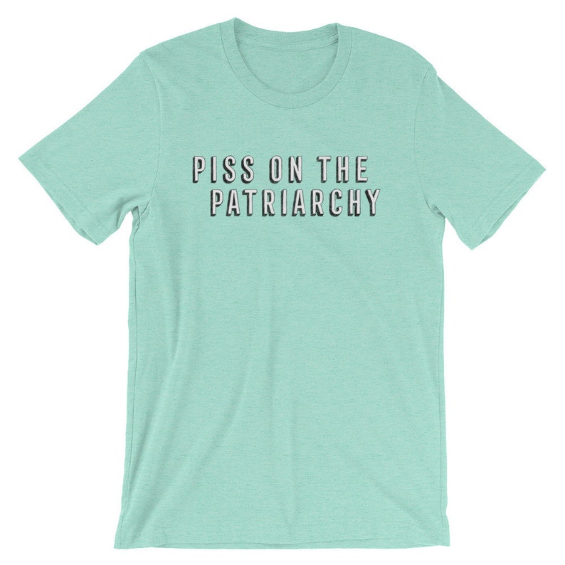 Puede incluir: Una camiseta azul claro con el texto "PISS ON THE PATRIARCHY" impreso en negro.