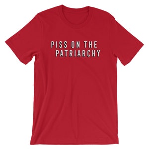 Puede incluir: Camiseta roja de manga corta con el texto "PISS ON THE PATRIARCHY" impreso en negro.