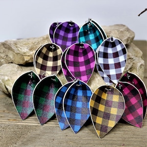 Op de afbeelding: Assortiment van geruite stoffen oorbellen in verschillende kleuren, waaronder zwart, wit, teal, paars, roze, bruin, geel en groen. De oorbellen zijn traanvormig en hebben zilveren haakjes.
