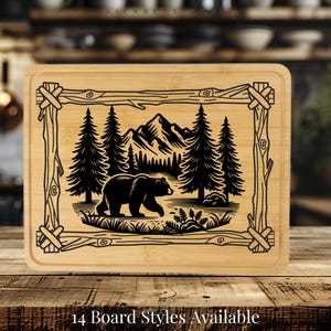 May include: A black and white illustration of a bear walking through a forest with mountains in the background. The image is engraved on a rectangular bamboo cutting board with a rustic wooden frame.