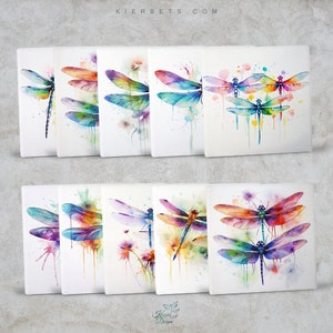May include: Set of 10 watercolor paintings of dragonflies with colorful wings and bodies. The dragonflies are painted on a white background with splatters of paint.