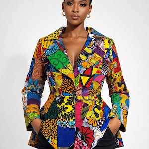 May include: A colourful patchwork blazer with a variety of patterns and hues, including red, yellow, blue, and green. The jacket has a tailored fit with a notched collar and long sleeves. The model is wearing black trousers.