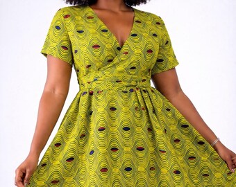 May include: A knee-length wrap dress featuring a vibrant chartreuse yellow base with a repeating pattern of black wavy lines and small, centered eye-shaped motifs in navy blue and deep red. The dress has short sleeves and a V-neckline.