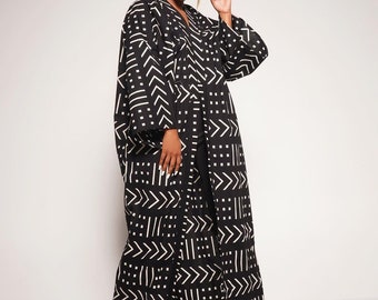 May include: A long black and white patterned robe with a kimono style collar. The robe has a geometric pattern of white lines and dots on a black background.
